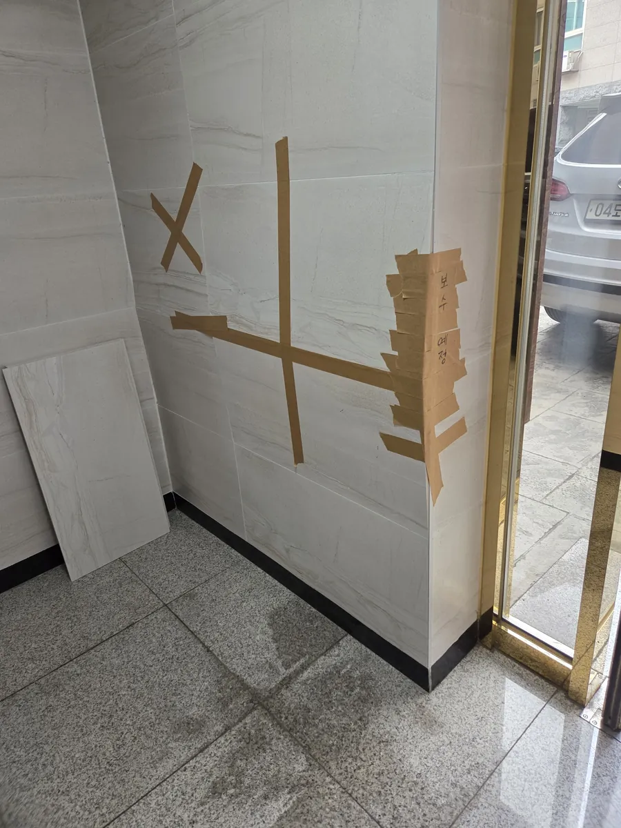 금간타일보수 — 상가 입구 벽 금 간 판재 작업 전